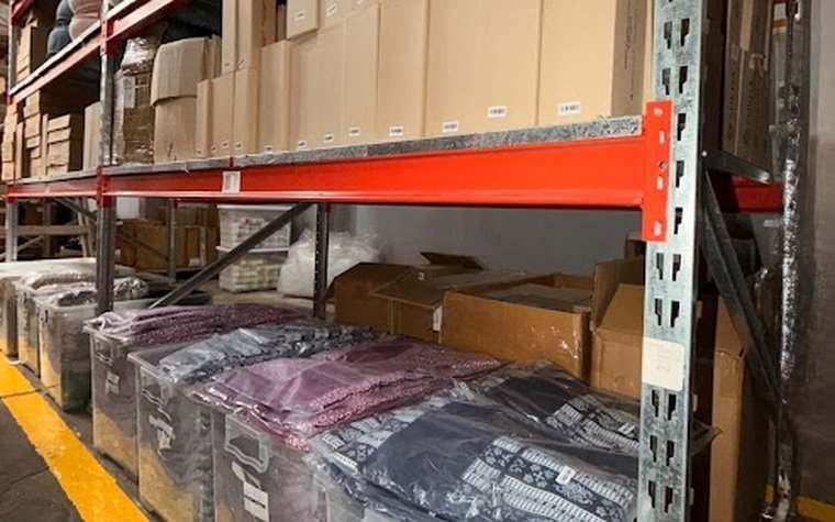 Mercadería embolsada y encajonada en los racks del depósito