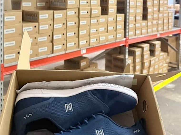 Zapatilla Neterwalk en su caja frente al rack de calzado